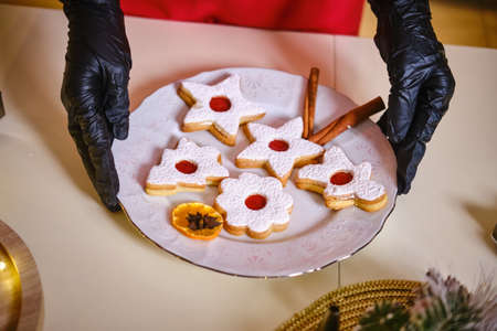 Female hands in black gloves hold a plate of cookies. Merry Christmas and Happy New Year.の写真素材
