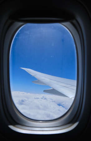 View through the window of the plane on Airplane wing on the blue skyの写真素材