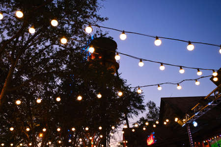 Wide shot of Hanging light bulbs in outdoor terrace, warm light source .の写真素材