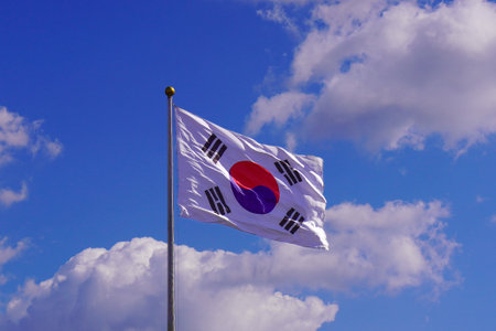 South Korea flag waving in the wind against blue sky with white cloudsの写真素材