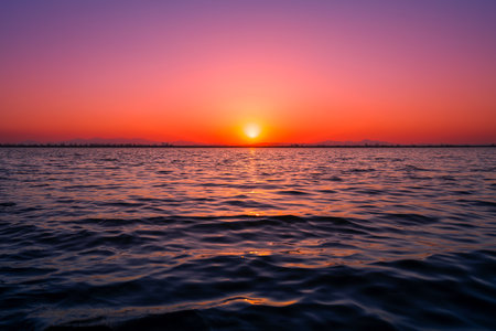Beautiful sunset on the sea. The sun goes down over the horizon.の写真素材