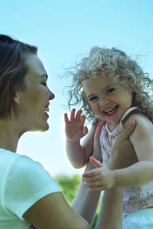 young girl being held by motherの写真素材