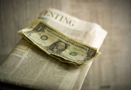 studio close up of dollar bills on newspaperの写真素材