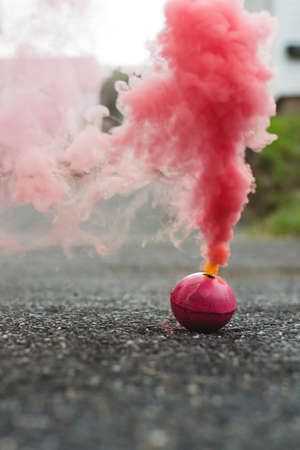 Red smoke bomb in the street smokingの写真素材
