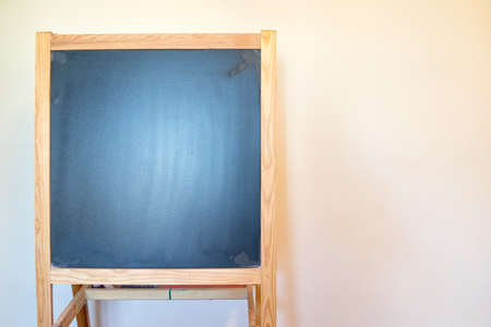 Small Wooden Chalk Board Stand Against Off White Wallの写真素材