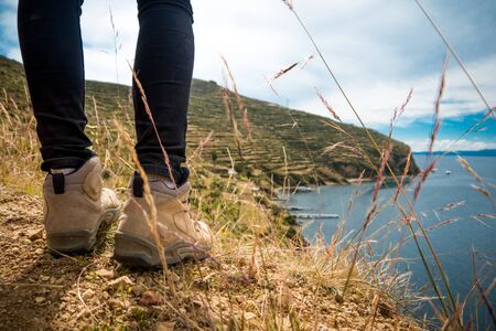 A hiker stands looking out to sea on Isla del Sol in Bolivia, South Americaの写真素材
