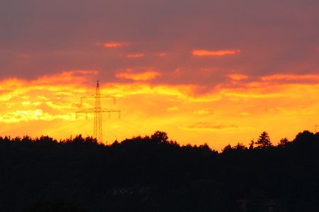 Beautiful sunset with electrical tower in frontの写真素材