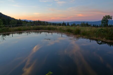 a little Pond next to the village Eck in the Bavarian Mountains at sundownの写真素材