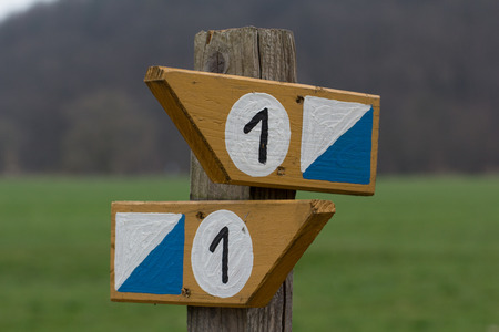 a wooden direction sign with the number oneの写真素材