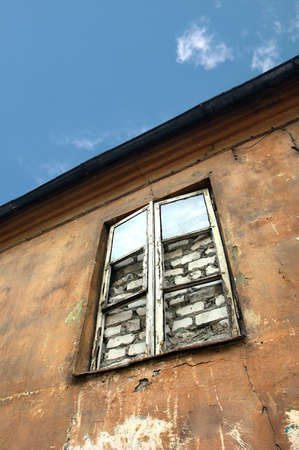 Low angle view at bricked over window of an old abandoned houseの写真素材