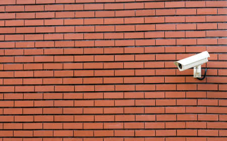 Cctv security camera on the brick wall with plenty of copy spaceの写真素材