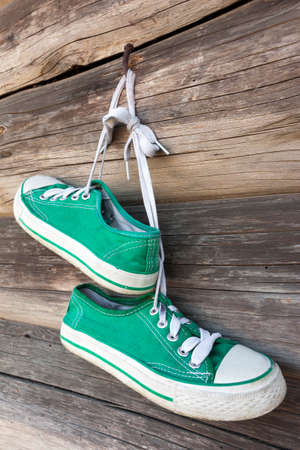 Pair of old sneakers hanging on the wall の写真素材