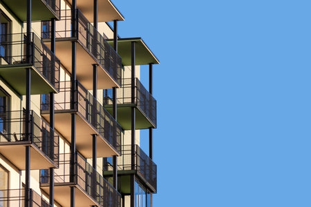 Modern apartment building with balconies against blue sky to ad textの写真素材
