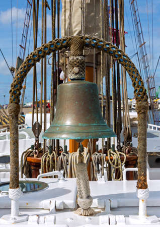 Closeup of ship deck with sail ropes and old bell made of copperの写真素材