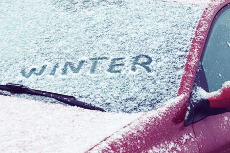 Word Winter written on a car windshield covered with fresh snowの写真素材
