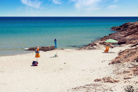 Empty tropical beach at summer with abandoned parasols in Sardinia, Italyの写真素材