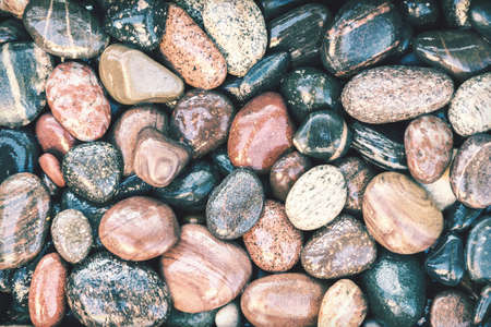Colorful wet pebbles background with retro faded photo effectの写真素材