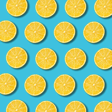Lemon slices pattern on vibrant turquoise color background. Minimal flat lay food texture の写真素材