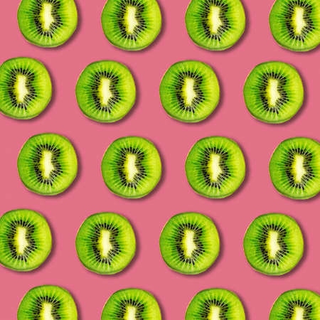 Kiwi fruit slices pattern on vibrant color background. Minimal flat lay food texture の写真素材