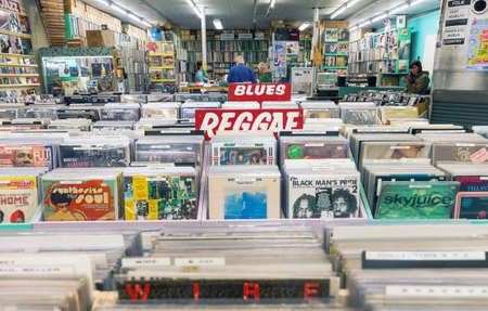 DELFT, NETHERLANDS - AUGUST 25, 2018: Old music record shop interior with racks full of vintage vinyl turnable records and customers wandering around.のeditorial素材