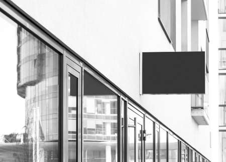 Blank hanging company wall sign to add business logo, sign or name, black and white modern mockupの写真素材