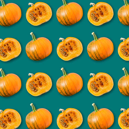 Geometric arrangement of ripe orange pumpkins on dark green background, colorful vegetable texture, vegan food pattern, autumn Haloween backgroundの写真素材
