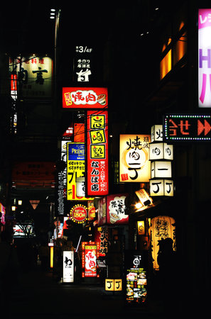 Osaka, Japan - February 22, 2020: Neon lights and billboard advertisements on the street in Osaka, Japan. High contrast nigh picture with glowing shop and restaurant signsのeditorial素材