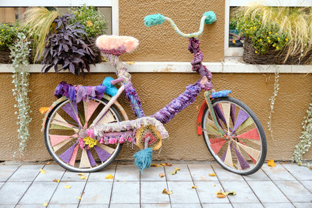 Old vintage colorful bicycle with knitted decoration standing on the streetの写真素材