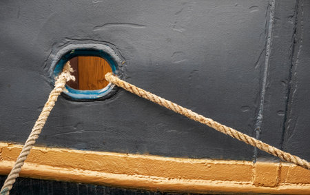 Old boat detail with mooring rope, maritime equipment closeupの写真素材