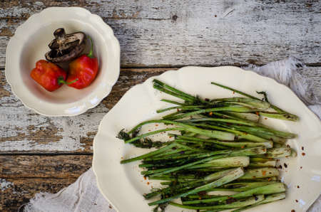 Asparagus on a white tray, with red peppers and mushrooms, on a white wooden backdrop.の写真素材