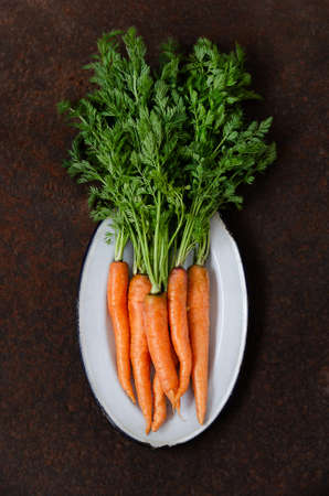 Carrot in a gray tray on a dark backdrop. Top view.の写真素材