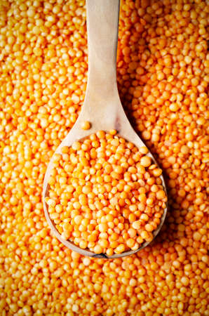 Red lentils in a wooden spoon. Top view.の写真素材