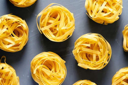 Nests of fettuccine pasta on a light blue background.の写真素材