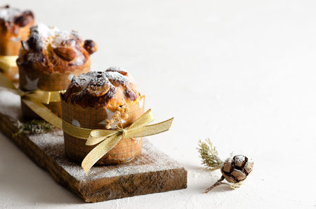 Mini panettone on a piece of wood on a white background.