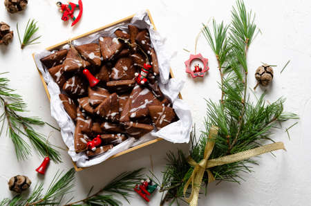 Chocolate cookies in a box, pine branches, and Christmas toys on a white background.の写真素材