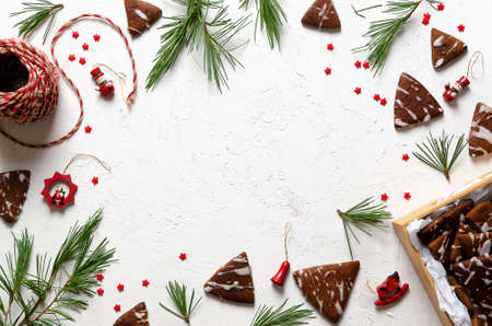 Pine branches, Christmas toys, little red stars, and chocolate cookies in a box and spread on a white background.の写真素材
