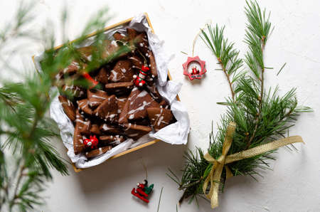 Chocolate cookies in a box, pine branches, and Christmas toys on a white background.の写真素材