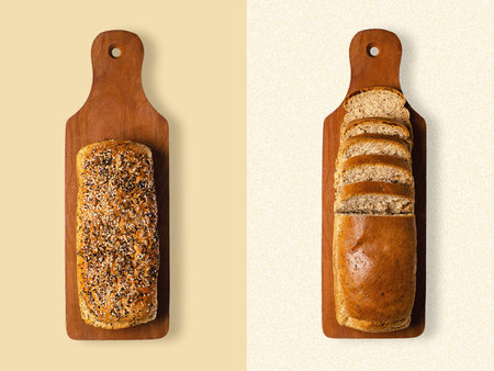 Two loaves of wholemeal bread on wooden cutting boards.