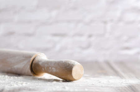 A rolling pin with white flour on wooden background. Copyspace.の写真素材