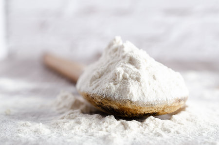A spoonful of white flour on wooden backdrop. Close-up.の写真素材