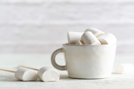 White marshmallows in a white cup on white background with copy space.の写真素材