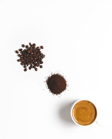 Coffee beans, grounded coffee, and a cup of coffee on white background. Vertical format with copy...
