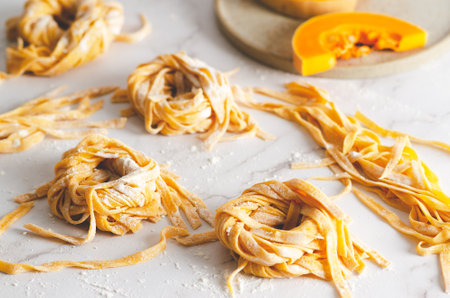 Butternut squash noodle nests and some slices of butternut squash in a plate, on marble background.の写真素材