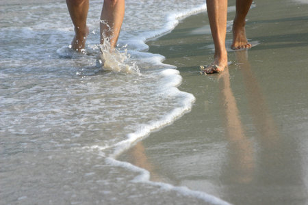 A Walk On The Beach - An image of a couple's legs walking side by side along the water's edge