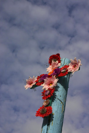 Cross Of Flowers - Vertical Format - Colourful flowers mounted in the shape of a cross against a blue sky. Photographed from a church in Cozumel, Mexico.の写真素材