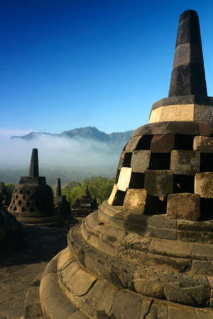Stupas on the upper terraces of the ancient temple of Borobudur, Indonesia, on a misty morningの写真素材