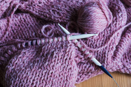 Violet cozy sweater hand knitted,ball of yarn,knitting needles on awooden backgroundの写真素材