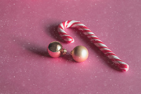 Christmas Stick of hard candy and bell on the snowy background