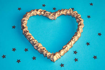 Romantic golden woodenheart on the blue background with starsの写真素材