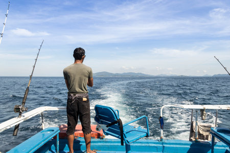Trolling fishing boat rod and fisherman was fishing in deep blue ocean sea wakeの写真素材